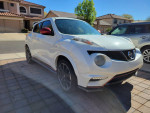 White Nissan Juke Nismo edition parked in a driveway, showcasing its sporty design and sleek aesthetics.