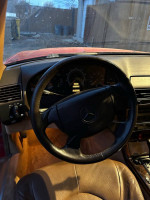 Interior view of a 1997 Mercedes-Benz SL500 with leather seats and steering wheel, showing mileage and dashboard.
