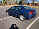 2006 Honda Civic four-door sedan in blue, showing interior features and minor rear damage.