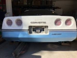 Rear view of a 1985 Chevrolet Corvette in need of repairs, showcasing original design and vintage features.
