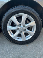 Close-up of a Mazda wheel with Yokohama tires on a 2010 Mazda 3, showcasing excellent condition.
