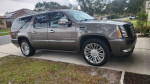 2012 Cadillac Escalade ESV Luxury SUV in bronze color parked on driveway with modern design and alloy wheels