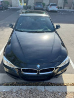 2013 BMW 335i M-Sport package in black with rare red interior, parked in a lot.