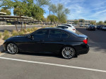 2013 BMW 335i with M-Sport package parked in lot, showcasing sleek black design and rare red interior.