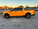 2023 Ford Maverick XLT in Cyber Metallic Orange parked on the street, showcasing its sleek design and new features.