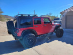2012 Jeep Wrangler Unlimited Rubicon 4WD parked outdoors, showcasing custom lift, off-road tires, and modifications.