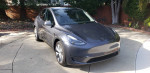 2023 Tesla Model Y Long Range AWD for sale, gray color, low mileage, salvaged title, parked on driveway.