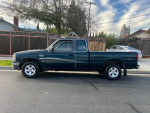1997 Mazda B4000 pickup truck in green color, parked on the street, showcasing its side profile.