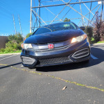 Front view of a black 2015 Honda Civic EX parked, showcasing its clean exterior and distinctive grille.