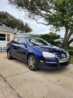 2006 Volkswagen Jetta TDI in Shadow Blue with black leather interior, parked in a residential area.