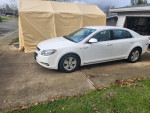 2008 Chevrolet Malibu hybrid parked in front of a garage, showcasing its clean exterior and well-maintained interior.