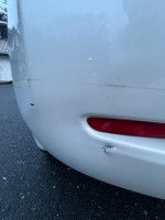 Close-up of the rear bumper of a 2017 Nissan Leaf S showing minor scratches and wear.