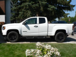 Side view of a 2022 GMC Canyon Elevation 4WD truck in white, featuring a long box and black alloy wheels.