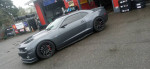 2010 Chevrolet Camaro LS with custom racing suspension and HID lights, parked at a tire shop.