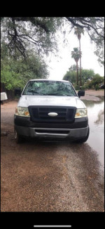 Front view of a 2006 Ford F150 XL with low mileage and original parts, parked on a gravel road.