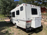 1990 Toyota Sunrader motor home with V6 engine, parked in a green area, showcasing LED lights and custom features.