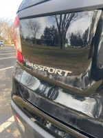 Close-up of the rear emblem on a 2019 Honda Passport Sport FWD, showcasing its reflective surface and sleek design.