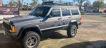 1993 Jeep Cherokee 4X4 in Gunmetal Gray parked, showcasing unique styling and cargo rack.