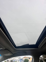 Sunroof view of a 2017 Subaru Outback 2.5i Limited, showcasing spacious interior and clear sky.
