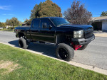 2007 Chevrolet Silverado 1500 4x4 with lifted suspension and aftermarket rims parked on the street