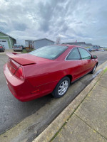 2000 Honda Accord LX in red, parked on the street, showcasing rear and side view on a cloudy day.