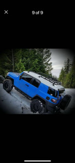 2007 Toyota FJ Cruiser in blue, equipped for off-road, parked in snowy terrain, showcasing rugged features and tires.