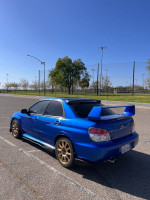 2007 Subaru Impreza STI in excellent condition, parked in a sunny area with clear blue sky.
