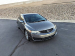 Front view of a 2010 Honda Civic EX Coupe parked on a driveway, showcasing its stylish design and premium wheels.