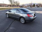 2010 Honda Civic EX Coupe parked, showcasing premium wheels and sleek design, ideal for reliable driving.