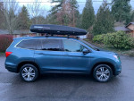 2017 Honda Pilot EX-L AWD with Yakima roof rack parked on a street, offering spacious seating for up to 8.