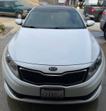 Front view of a 2012 Kia Optima SX in white, featuring upgraded rims and a clean interior.