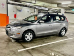 2012 Hyundai Elantra Touring in grey parked in a garage, featuring roof racks and all-weather tires.