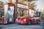 1973 Porsche Speedster replica parked at a gas station, showcasing its classic design and vibrant red color.