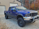 Blue 2004 Ford F350 King Ranch 4x4 with aftermarket wheels parked outside.